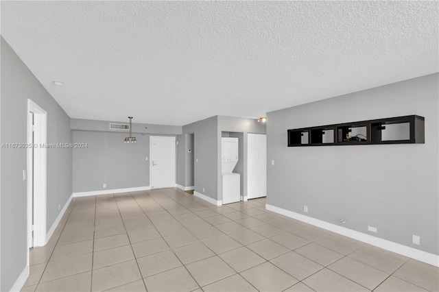 spare room with a textured ceiling and light tile patterned floors