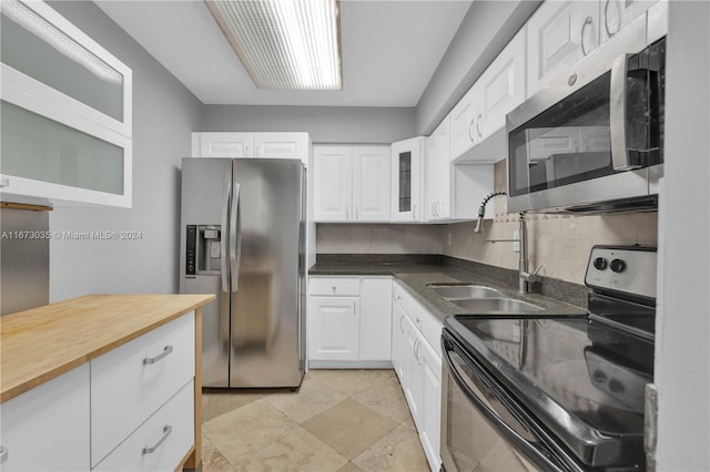 3300 NE 192nd St Unit 1108, Aventura, FL 33180 - kitchen with stainless steel appliances, white cabinets, butcher block countertops, a sink, and glass insert cabinets