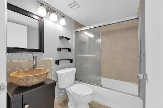 full bathroom featuring tile patterned flooring, vanity, toilet, and bath / shower combo with glass door