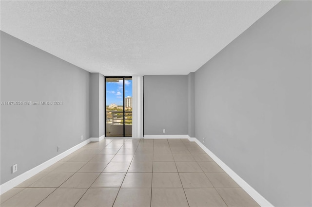 3300 NE 192nd St Unit 1108, Aventura, FL 33180 - unfurnished room with a textured ceiling, light tile patterned flooring, floor to ceiling windows, and baseboards