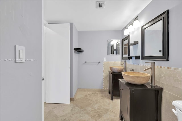 bathroom featuring vanity, tile walls, tile patterned flooring, and toilet