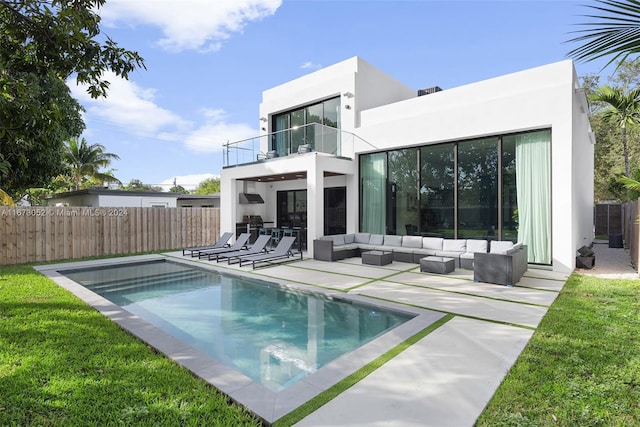 rear view of property with a patio, outdoor lounge area, a fenced in pool, a yard, and a balcony