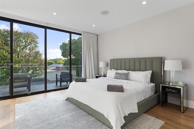 bedroom with wood-type flooring and access to exterior