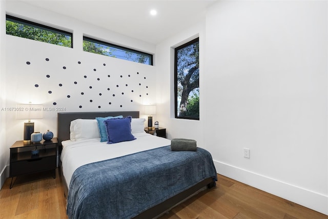 bedroom featuring multiple windows and hardwood / wood-style flooring