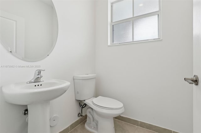 bathroom featuring toilet, sink, and tile patterned floors