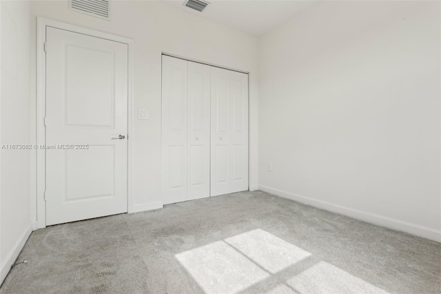 unfurnished bedroom with light carpet and a closet