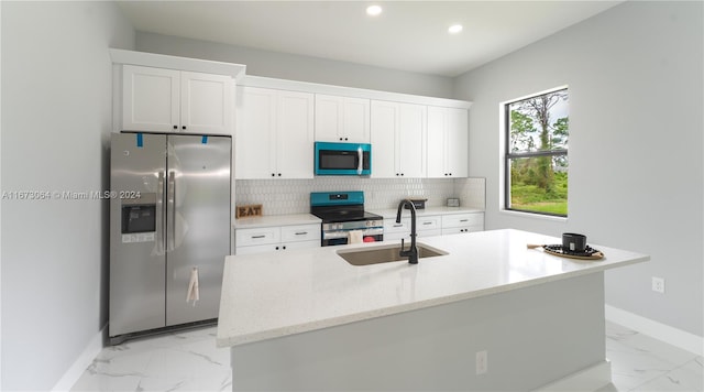 kitchen with a center island with sink, sink, white cabinets, and stainless steel appliances