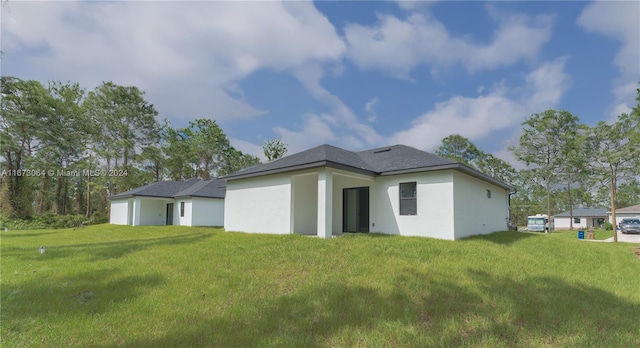 rear view of house featuring a yard