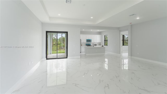 unfurnished living room featuring a raised ceiling