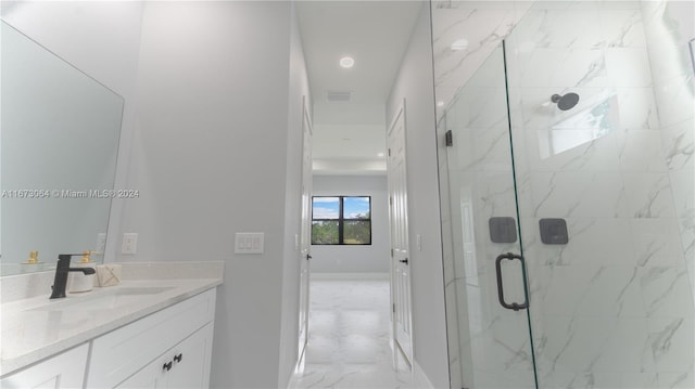 bathroom featuring a shower with door and vanity