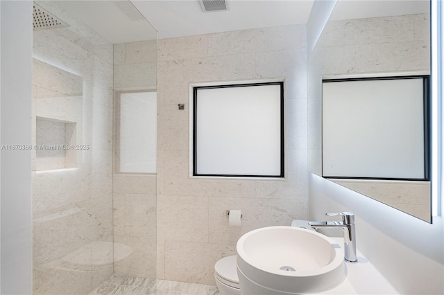 bathroom featuring walk in shower, sink, tile walls, and toilet