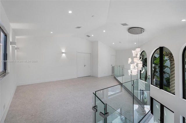 hall with light colored carpet and lofted ceiling