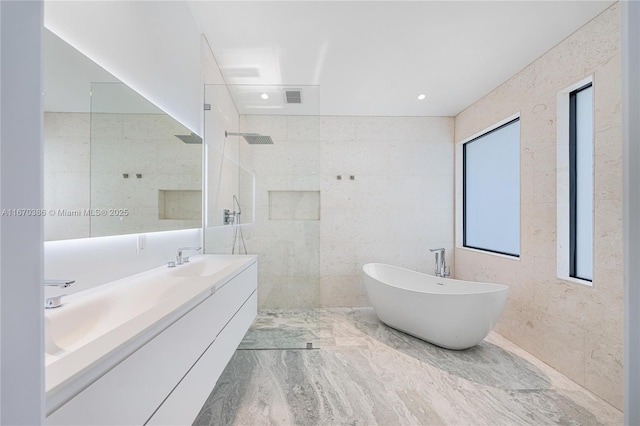 bathroom featuring shower with separate bathtub, vanity, and tile walls