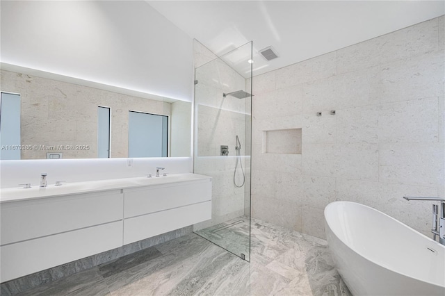 bathroom featuring vanity, tile walls, and plus walk in shower