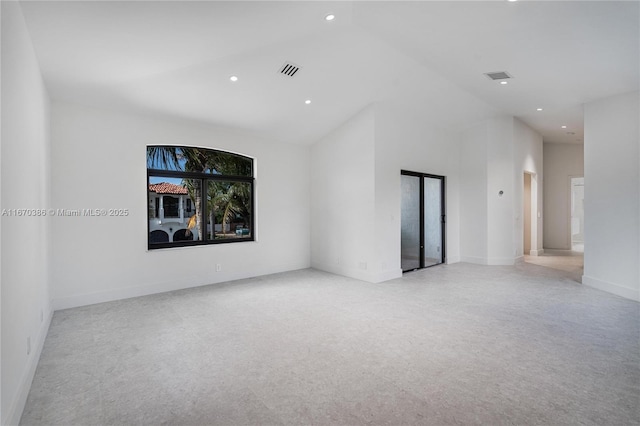 unfurnished room featuring a towering ceiling and light colored carpet