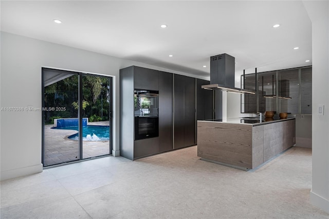 kitchen with island exhaust hood, kitchen peninsula, double oven, and sink