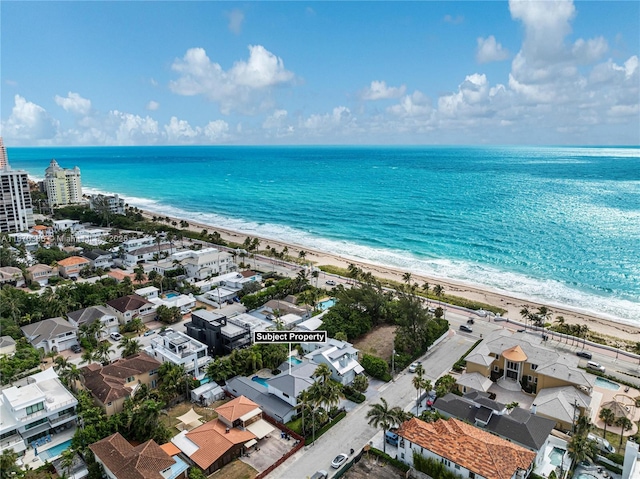 birds eye view of property with a beach view and a water view