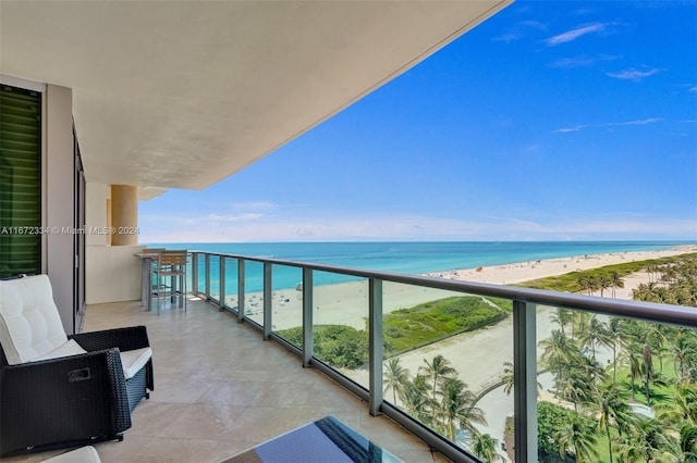 balcony featuring a water view and a view of the beach