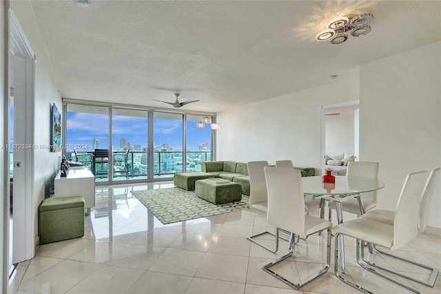 dining room with a textured ceiling, light tile patterned floors, floor to ceiling windows, and ceiling fan