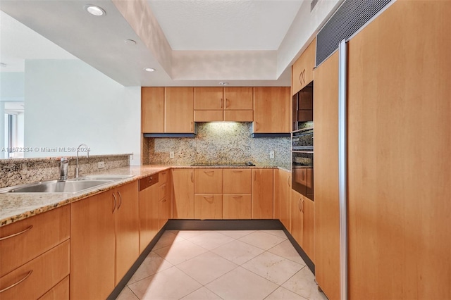 kitchen with black appliances, sink, light tile patterned flooring, backsplash, and a raised ceiling