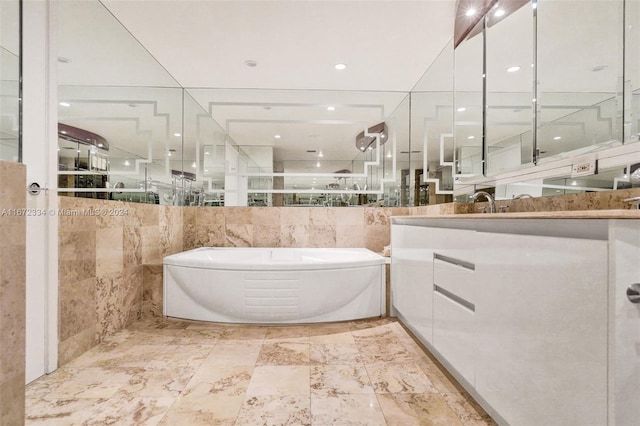 bathroom featuring vanity, tile walls, and a bathtub