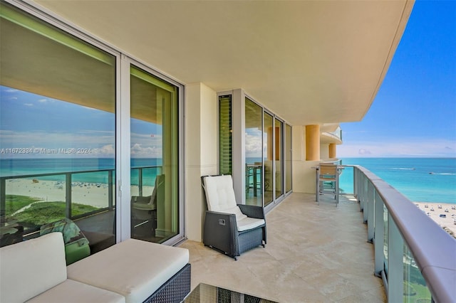 balcony featuring a water view and a beach view