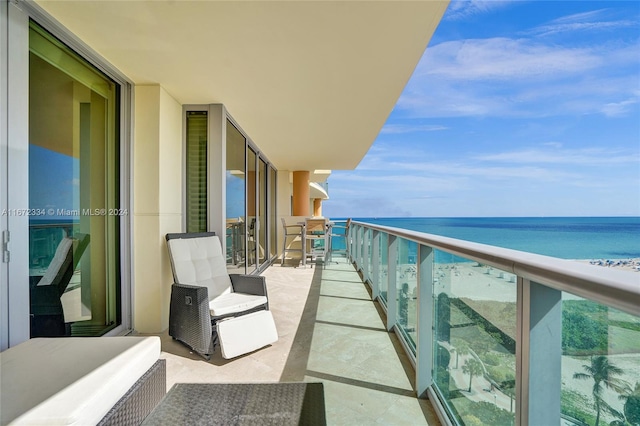 balcony featuring a water view and a view of the beach