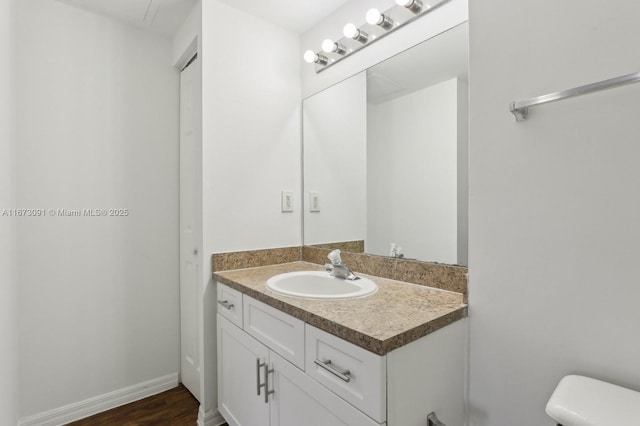 bathroom with hardwood / wood-style flooring, vanity, and toilet