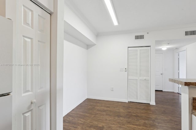 unfurnished room featuring dark hardwood / wood-style floors and crown molding