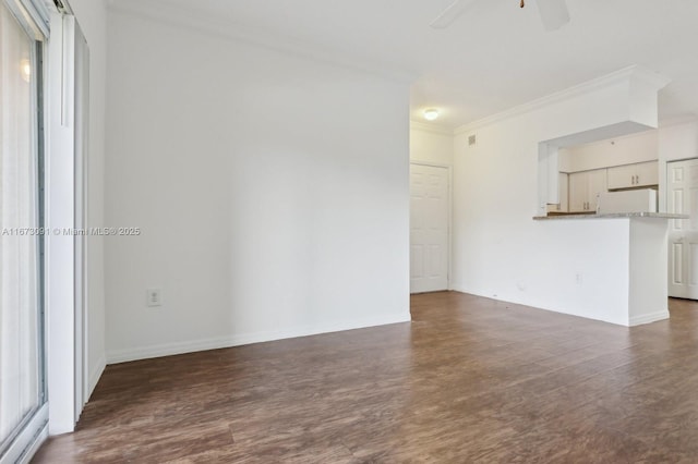 empty room with dark hardwood / wood-style floors, ceiling fan, and ornamental molding