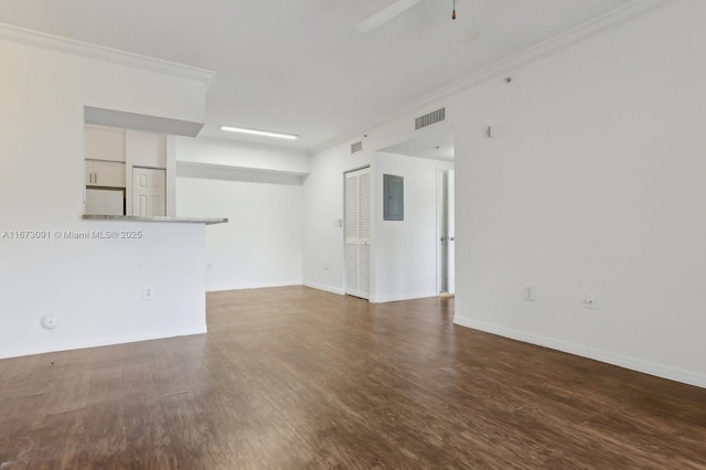 empty room with dark hardwood / wood-style flooring, ornamental molding, and electric panel