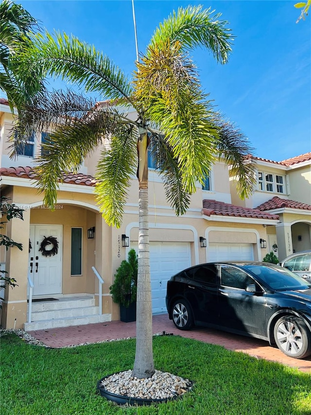 mediterranean / spanish-style house featuring a front yard and a garage