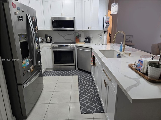 kitchen featuring white cabinetry, decorative light fixtures, stainless steel appliances, and sink