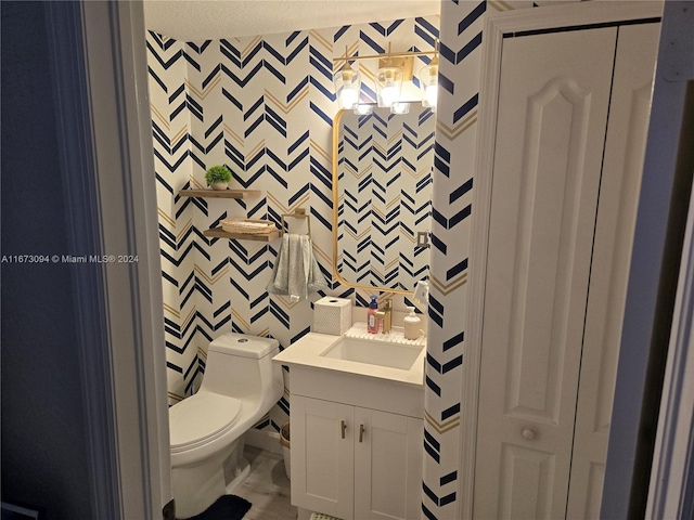 bathroom with vanity, a textured ceiling, and toilet