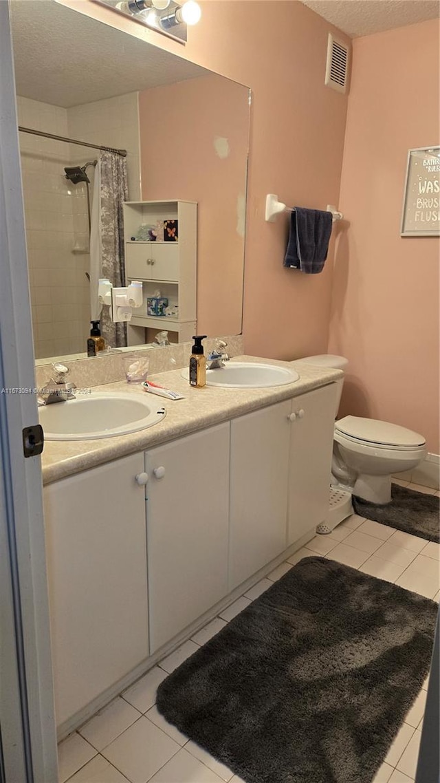 bathroom featuring vanity, a shower with shower curtain, toilet, and tile patterned flooring