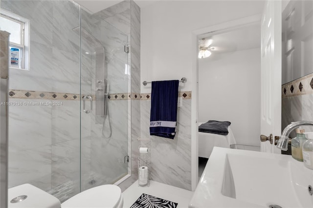 bathroom with ceiling fan, vanity, toilet, and a shower with door