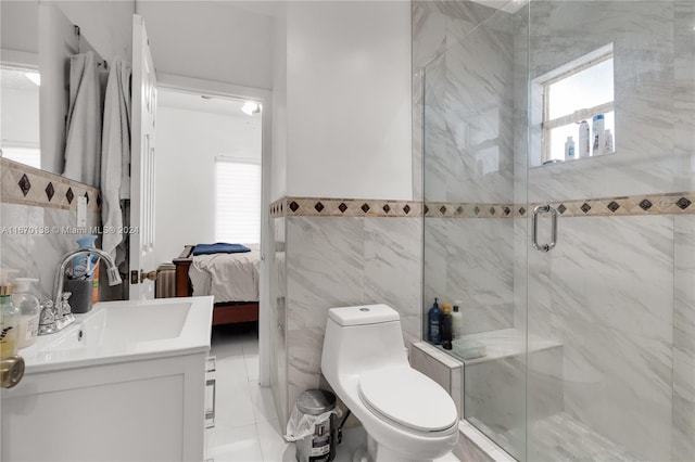 bathroom featuring tile walls, vanity, tile patterned flooring, a shower with door, and toilet