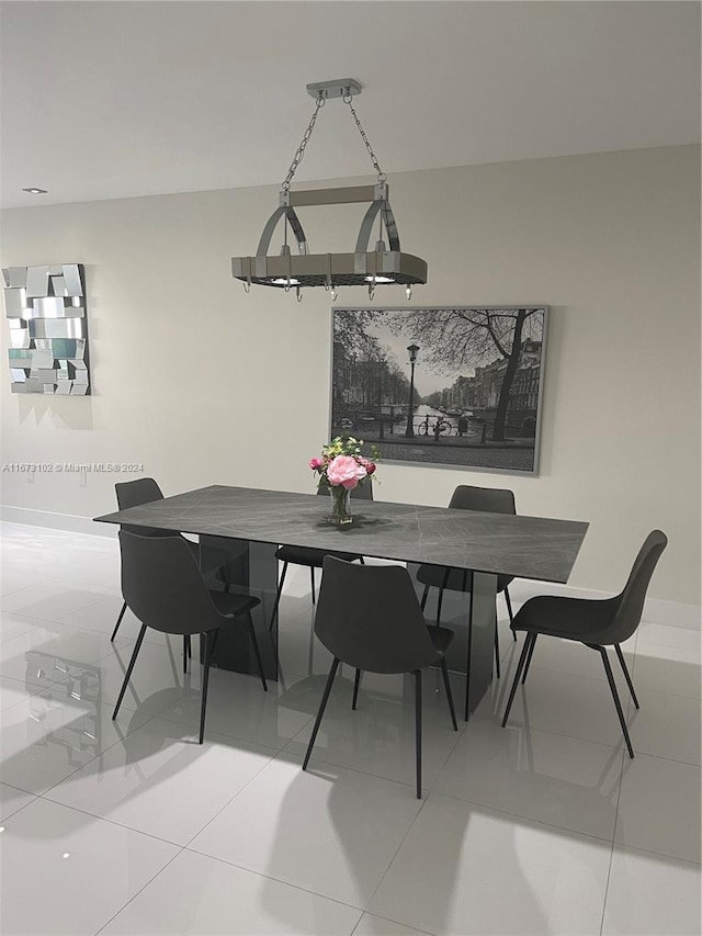 tiled dining area featuring an inviting chandelier