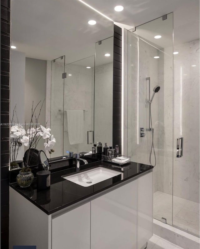 bathroom with vanity and a shower with shower door