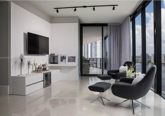 living room featuring a healthy amount of sunlight, wine cooler, and a wall of windows