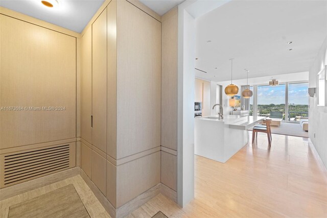 hall with light wood-type flooring and sink