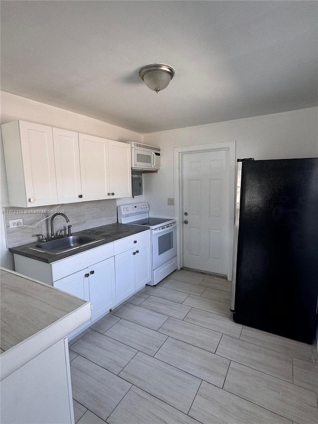 kitchen featuring white appliances, tasteful backsplash, white cabinetry, and sink