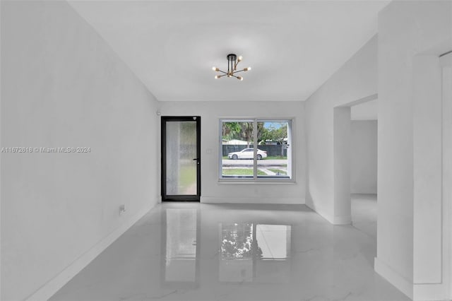 empty room featuring an inviting chandelier and lofted ceiling