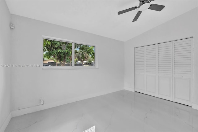 unfurnished bedroom with lofted ceiling, a closet, and ceiling fan