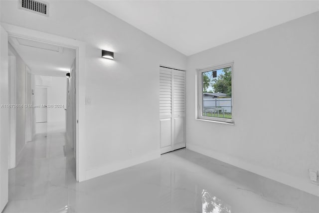 unfurnished bedroom with a closet and vaulted ceiling