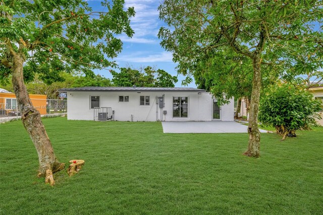 rear view of house featuring a yard, a patio area, and central AC