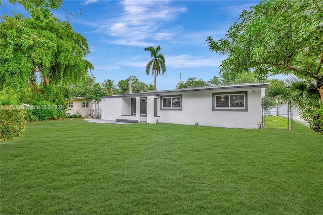 rear view of property featuring a lawn