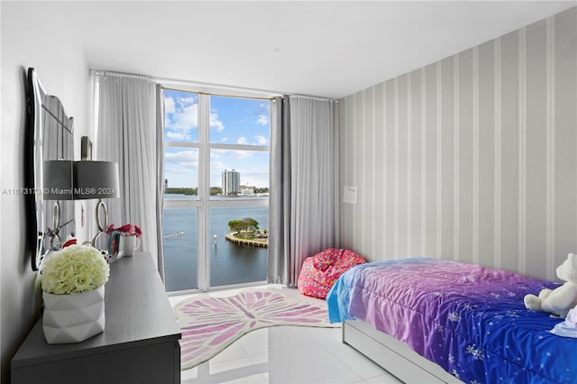 bedroom featuring a water view and tile patterned flooring