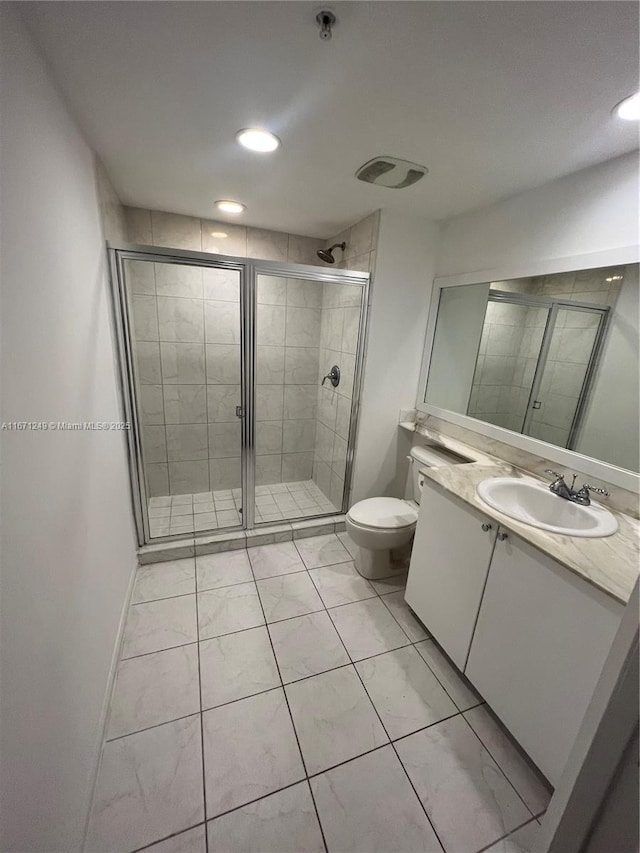 bathroom featuring toilet, a shower with door, and vanity