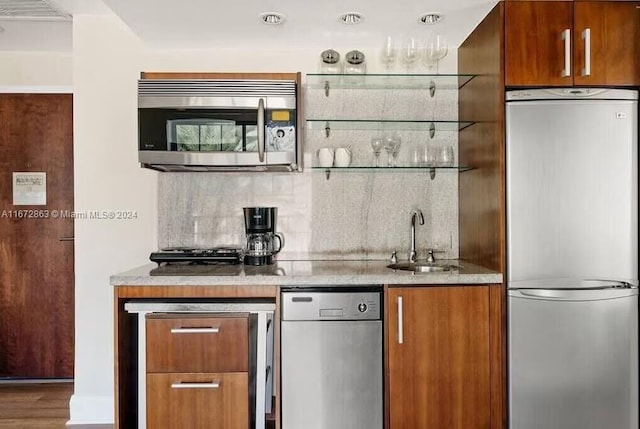 kitchen with decorative backsplash, sink, stainless steel appliances, and hardwood / wood-style flooring